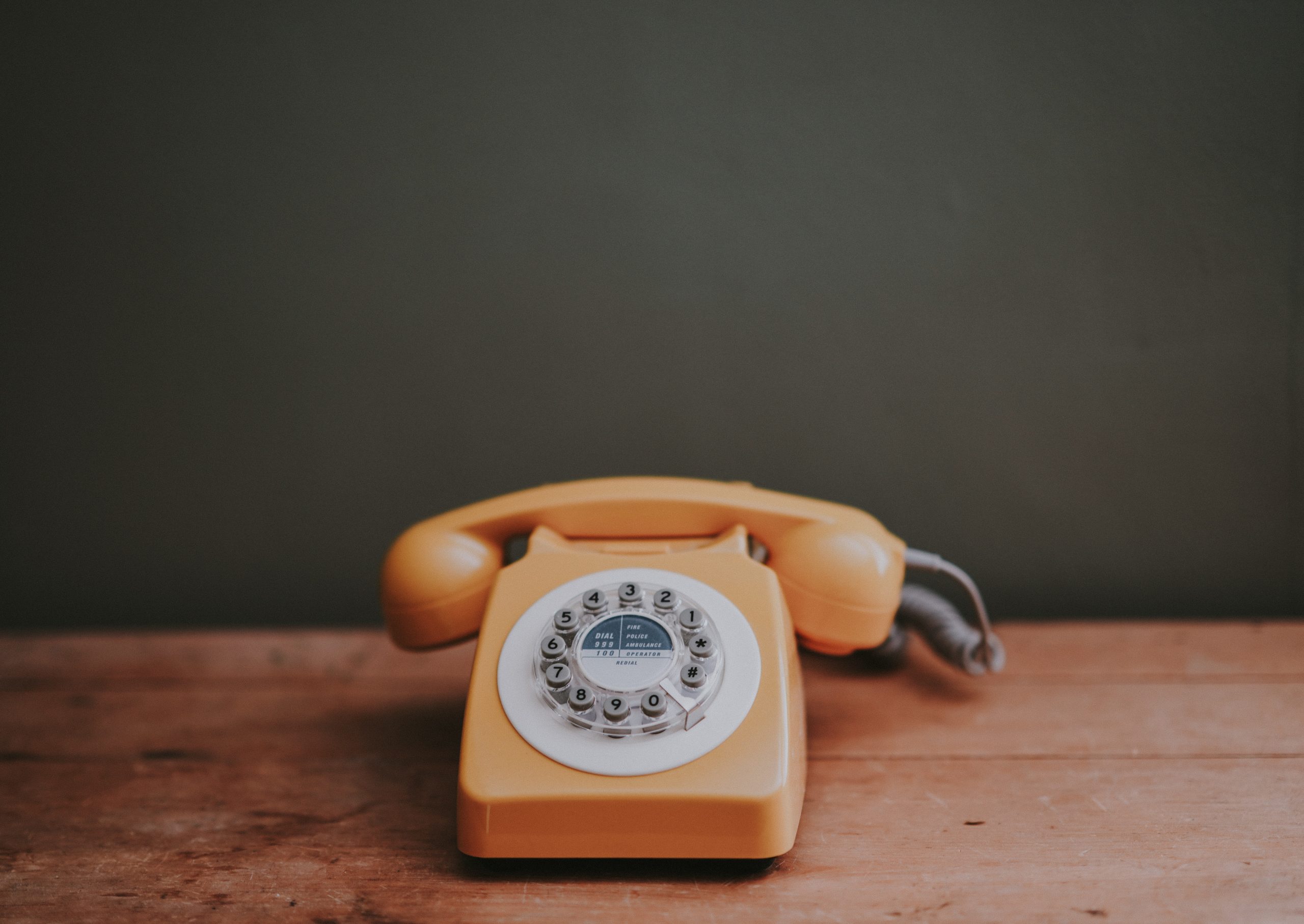 orange telephone on a table