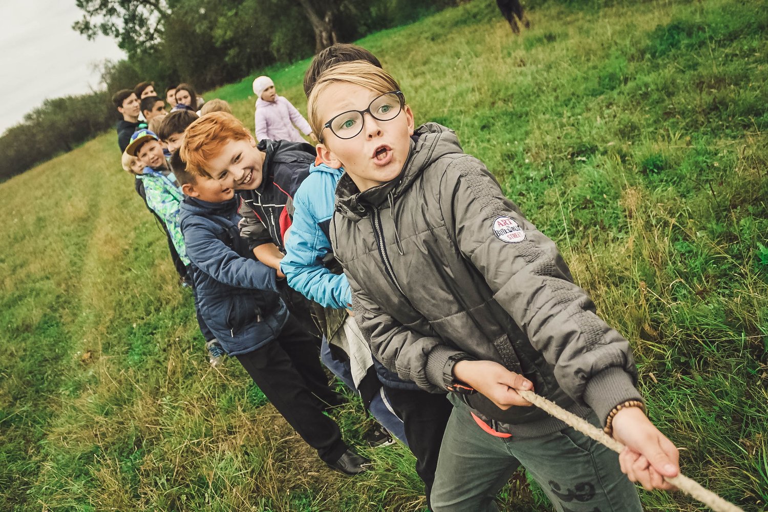 kids playing tug of war on the grass