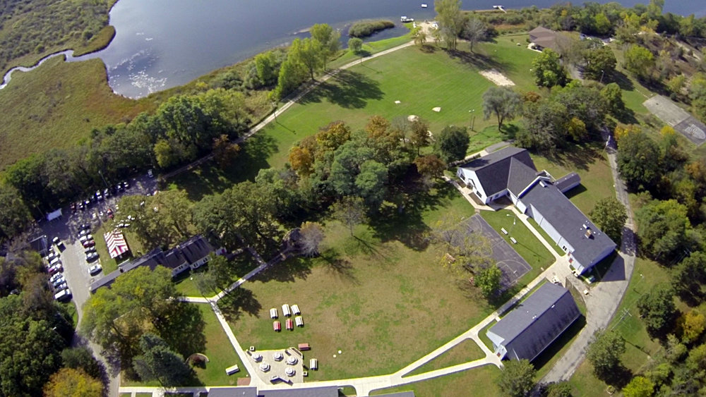 aerial shot of buildings on a lawn by water