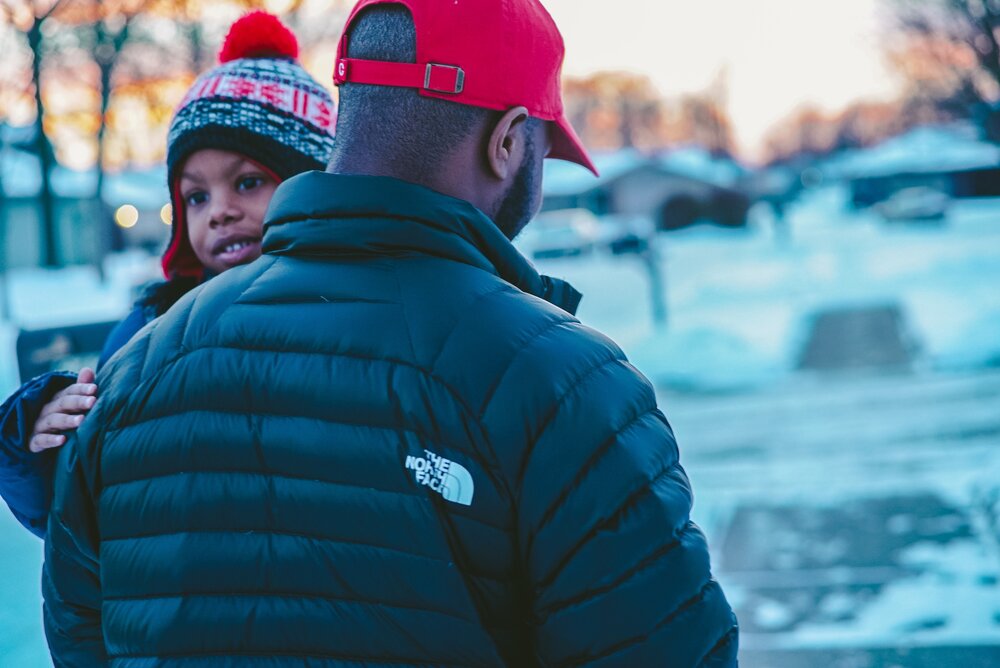 person holding a child outside in the winter