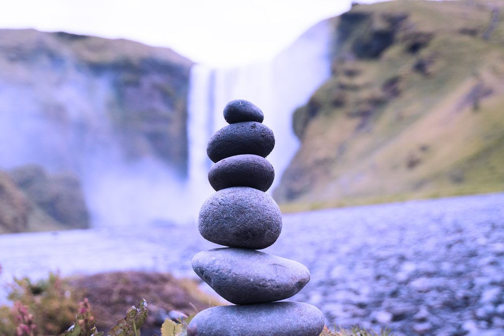 stacked stones in front of waterfall